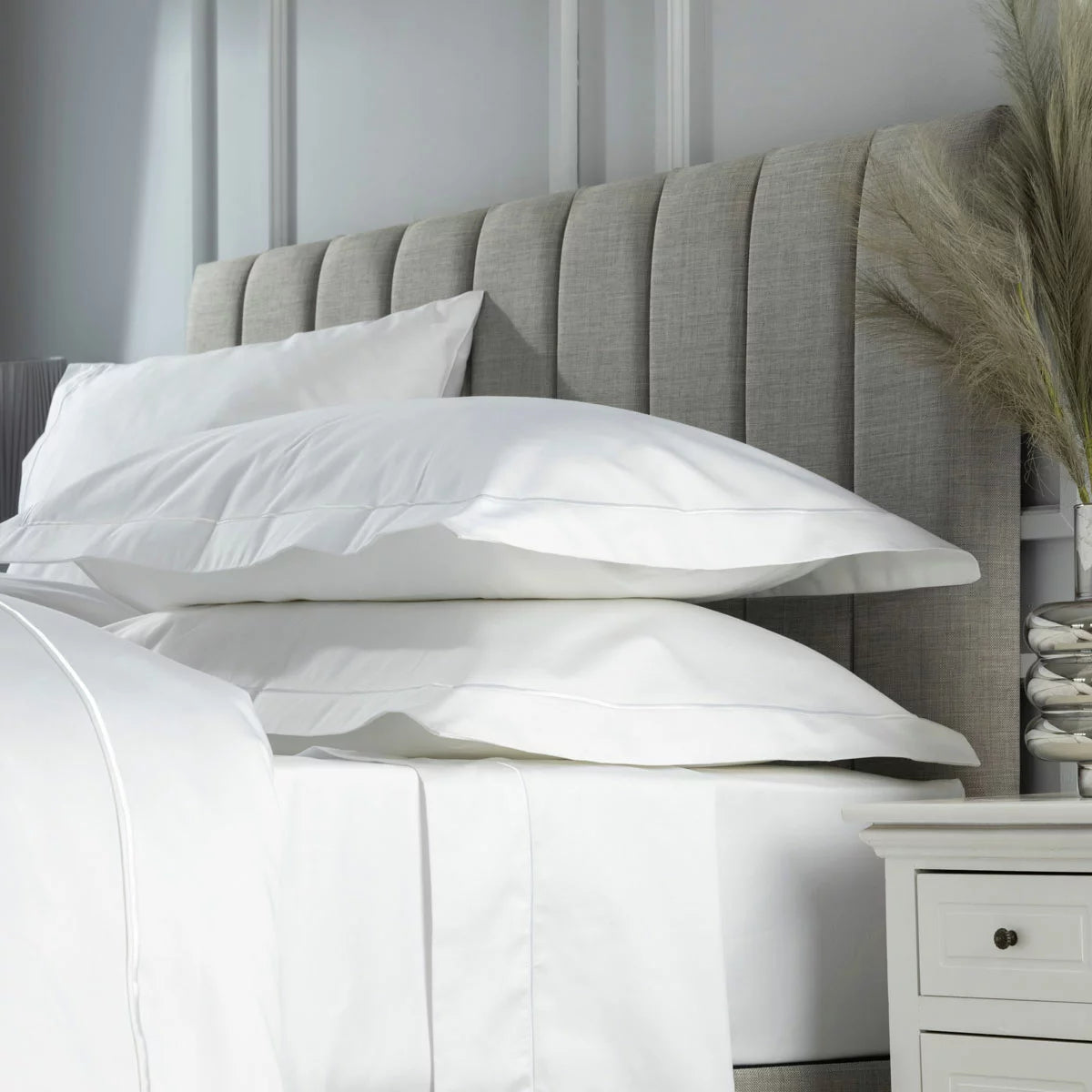 Belledorm 1200 thread count white Oxford pillowcase pair showcasing the elegant decorative border on a luxury mattress