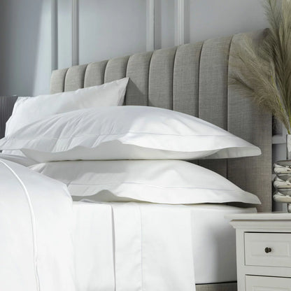 Belledorm 1200 thread count white Oxford pillowcase pair showcasing the elegant decorative border on a luxury mattress