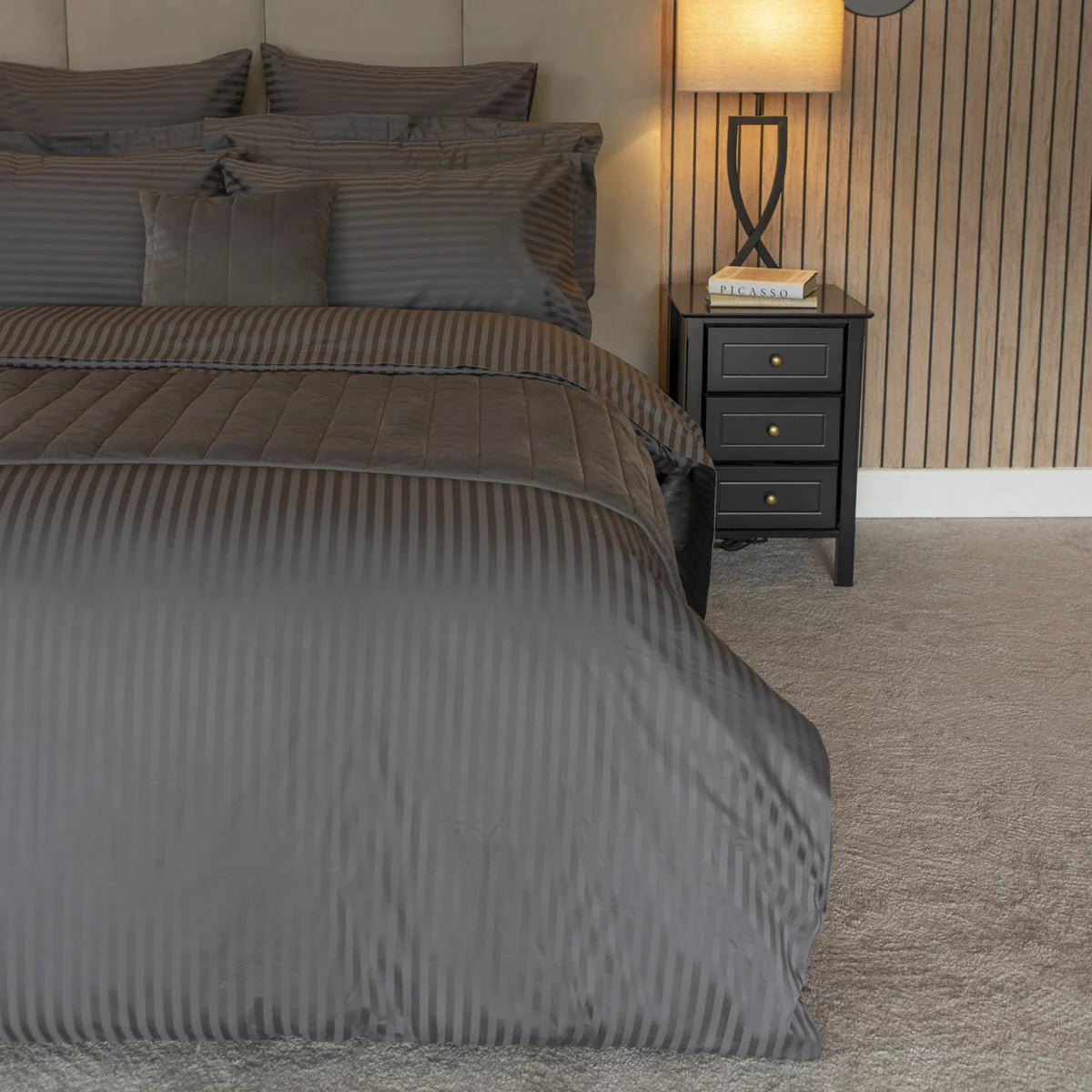 Flat lay of the Belledorm 540 thread count charcoal satin stripe double duvet cover set with matching pillowcases arranged neatly on a modern bed.