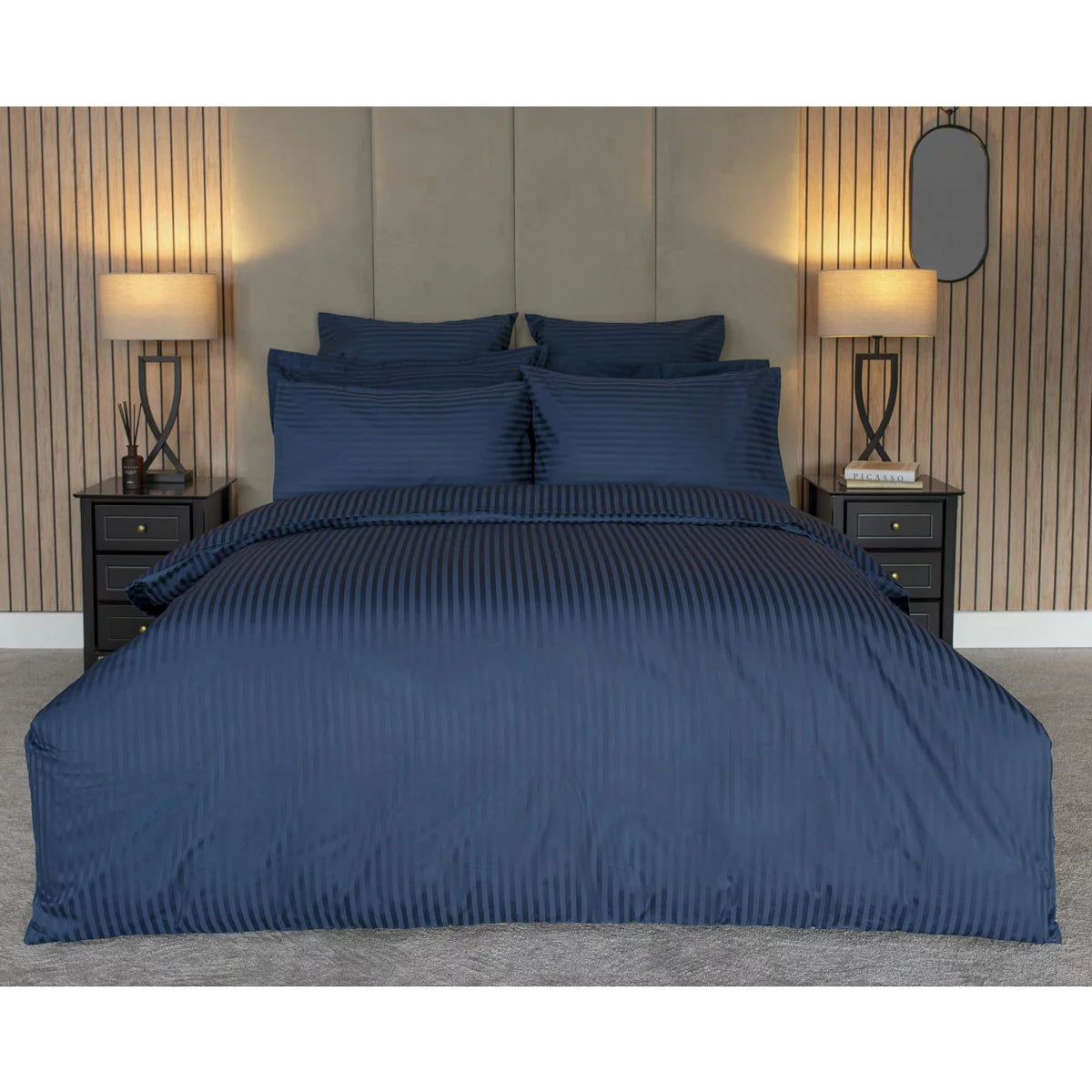 Flat lay image of the Belledorm 540 thread count navy satin stripe duvet cover set with matching pillowcases neatly arranged on a modern wooden bed.