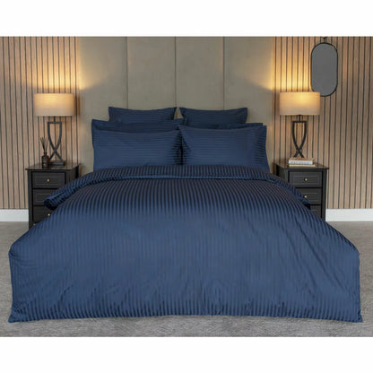 Flat lay image of the Belledorm 540 thread count navy satin stripe duvet cover set with matching pillowcases neatly arranged on a modern wooden bed.