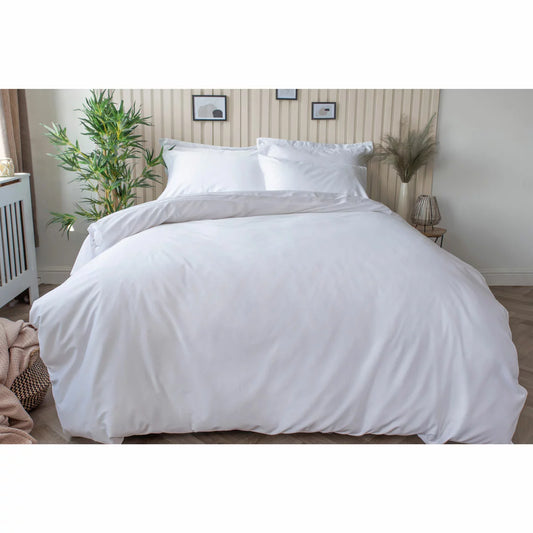 Close-up view of the crisp white Belledorm bamboo-cotton fitted sheet stretched tightly over the corner of a thick single mattress in a bright bedroom.