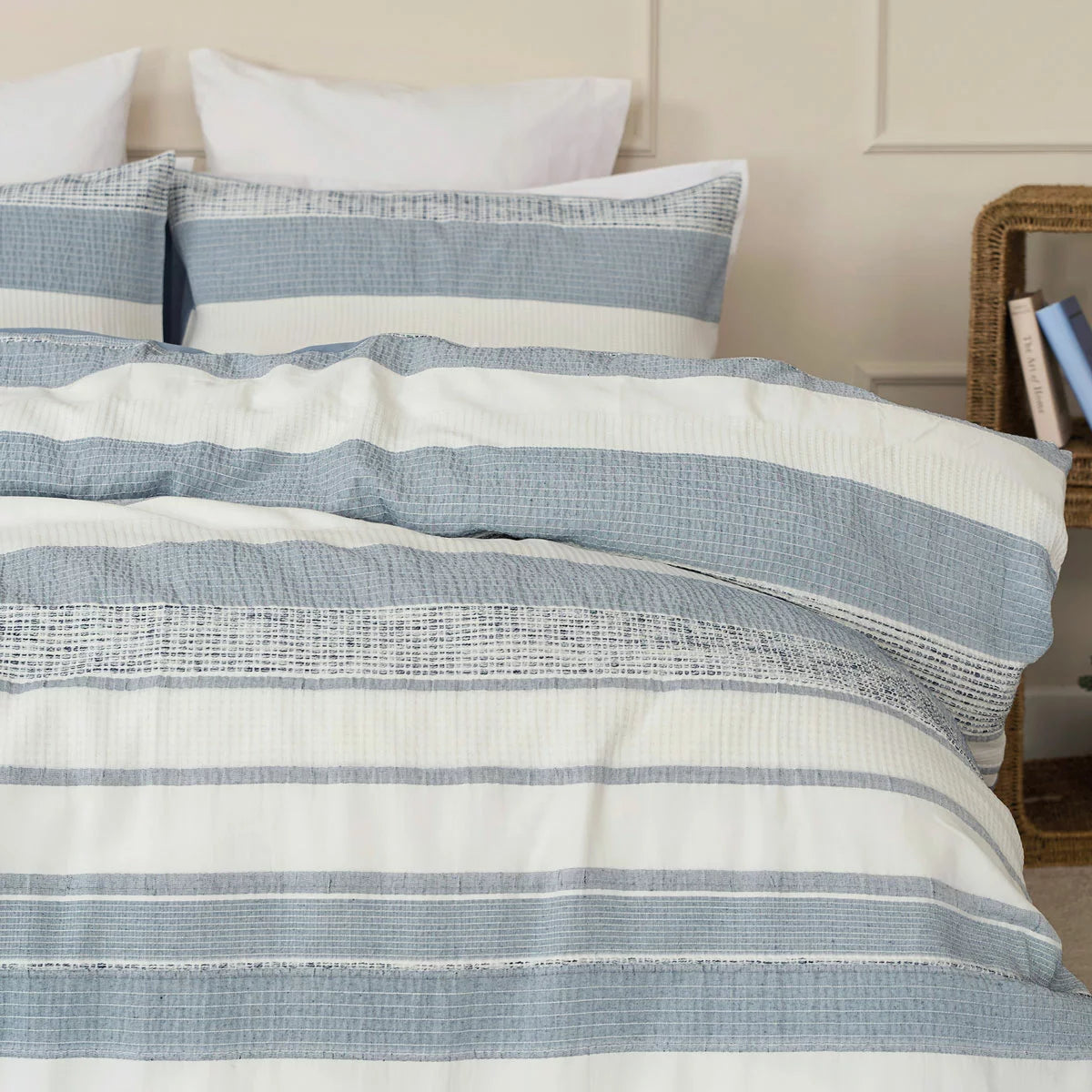 A close-up view of the Belledorm Rahil blue duvet cover set showing the detailed blue and white waffle weave pattern and sturdy button closure.