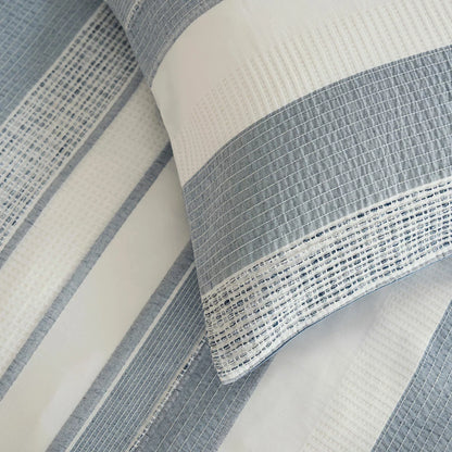 A close-up view of the Belledorm Rahil blue duvet cover set showing the detailed blue and white waffle weave pattern and sturdy button closure.