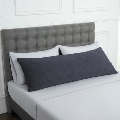 Below Zero cooling body pillow in a soft neutral tone with a textured circular-knit cover resting on a contemporary bed setting.
