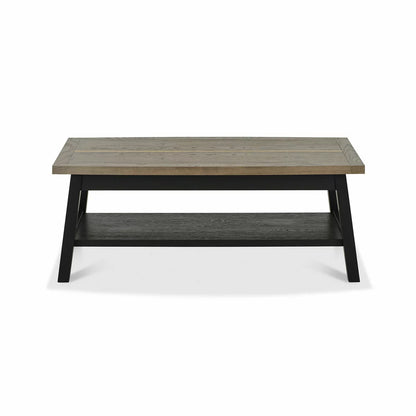 Angle view of the Bentley Designs Camden Coffee Table showing its weathered oak top, brass inlays, and dark peppercorn A-frame legs in a modern living room setting.