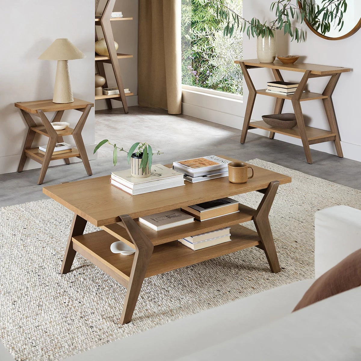 Bentley Designs Kristen light oak oval coffee table featuring a two-tone oak finish, lower open storage shelf, and splayed solid wood legs.