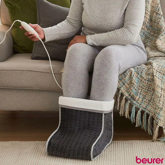 The Beurer FW20 electric foot warmer in its cozy teddy fleece finish, showcasing the soft-touch exterior and heating controller.