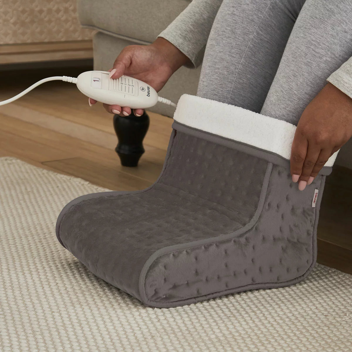 The Beurer FW20 electric foot warmer in its cozy teddy fleece finish, showcasing the soft-touch exterior and heating controller.