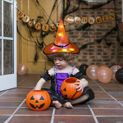 A black Halloween LED light-up witch hat glowing warmly while hanging against a dark background outdoors.