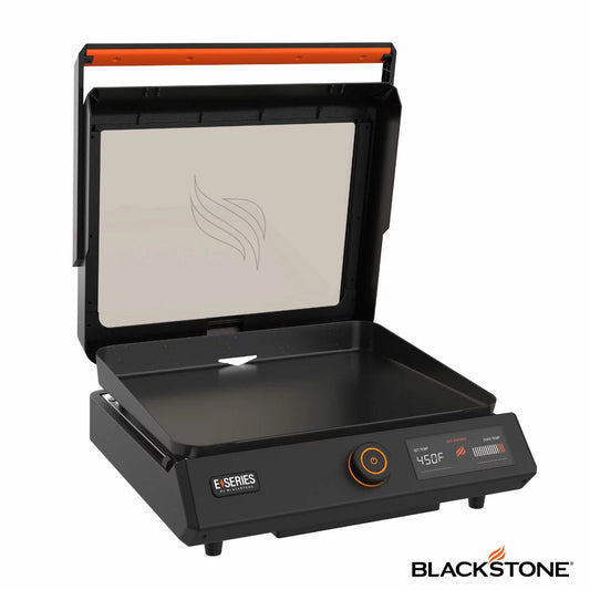 A Blackstone E-Series 17" electric griddle in a modern kitchen setting, showing the sleek glass hood, digital LCD control panel, and large non-stick ceramic cooking surface.