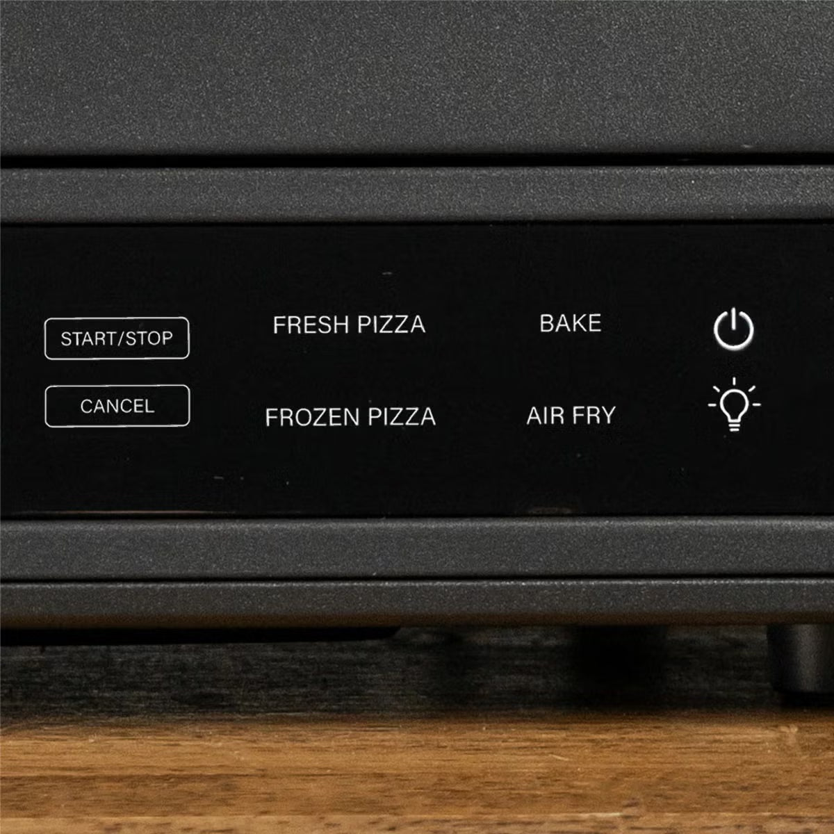 Front view of the black Blackstone E-Series electric pizza and air fryer oven sitting on a kitchen counter displaying its touchscreen control panel and open glass door with a 14 inch rotating deck inside.