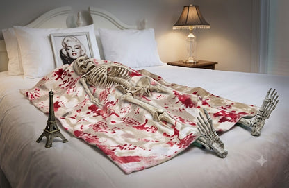Top-down view of the Bloody Death Bed Skeleton Halloween decoration featuring realistic bloodstains on dark fabric resting on a wooden party table setting.