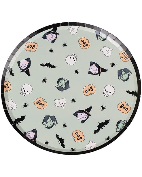 A stack of colorful ghost-patterned Boo Crew paper plates arranged neatly on a dark wooden Halloween buffet table next to seasonal treats.