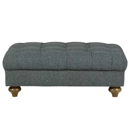 Angled shot of the Bordeaux buttoned fabric footstool in deep blue, showcasing its hand-tied tufting, textured linen-style fabric, and dark stained solid wood legs on a neutral rug.