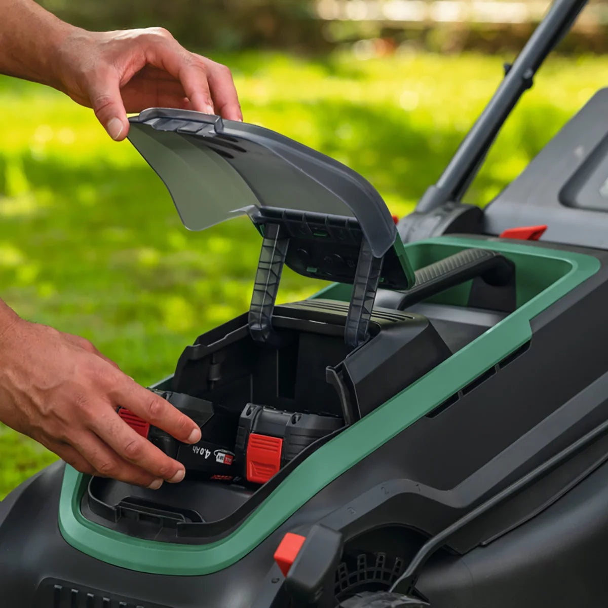 Bosch Rotak 36V cordless lawnmower with 43cm cutting width mowing a well-maintained residential garden