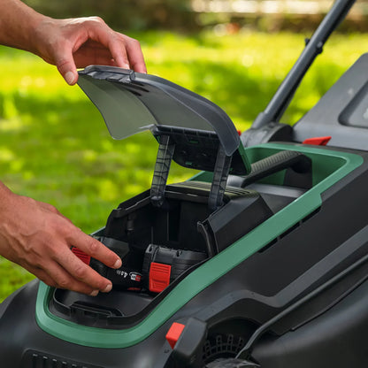 Bosch Rotak 36V cordless lawnmower with 43cm cutting width mowing a well-maintained residential garden