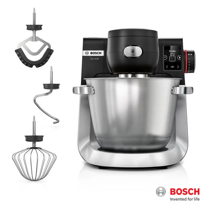 The Bosch Series 6 MUMS6ZM00G stand mixer in a professional setting, featuring the stainless steel mixing bowl, LED display, and the included professional whisk and hook attachments