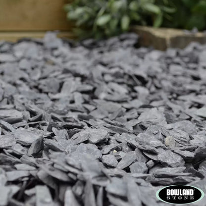 Bowland Stone 40mm Blue Slate displayed in a garden border, showcasing its natural texture and depth of colour.