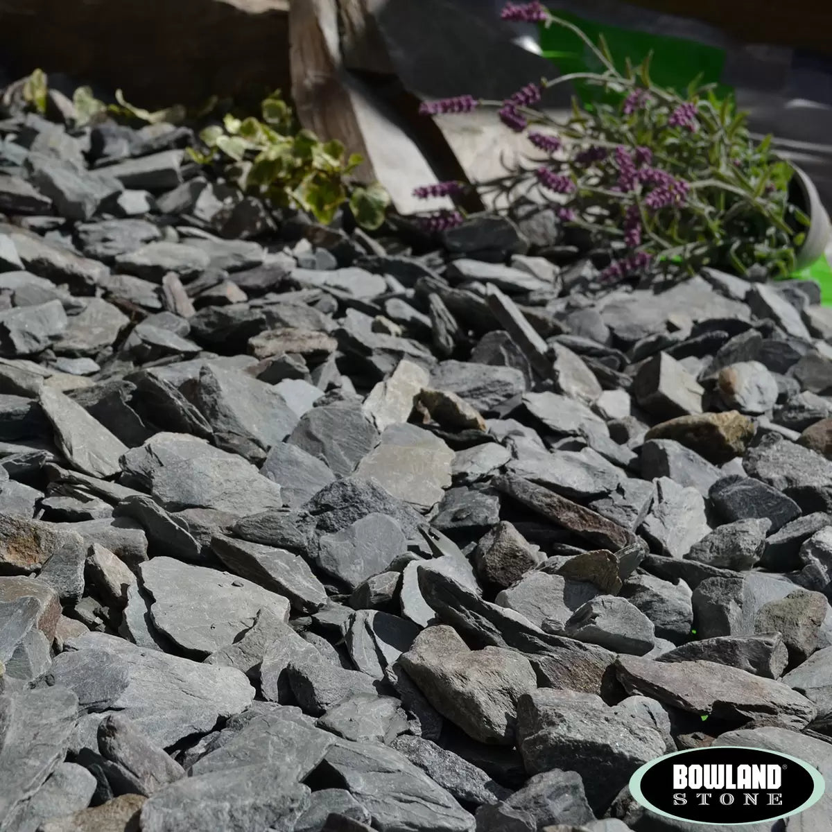 Bowland Stone 20mm Green Slate displayed in a garden border, showcasing its natural texture and depth of colour.