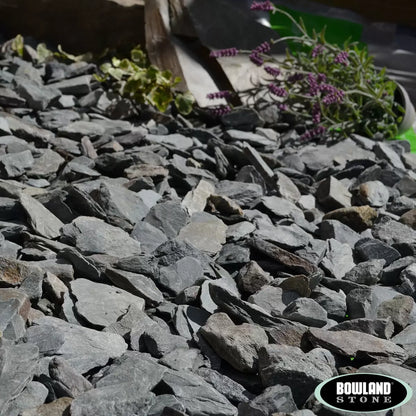 Bowland Stone 20mm Green Slate displayed in a garden border, showcasing its natural texture and depth of colour.