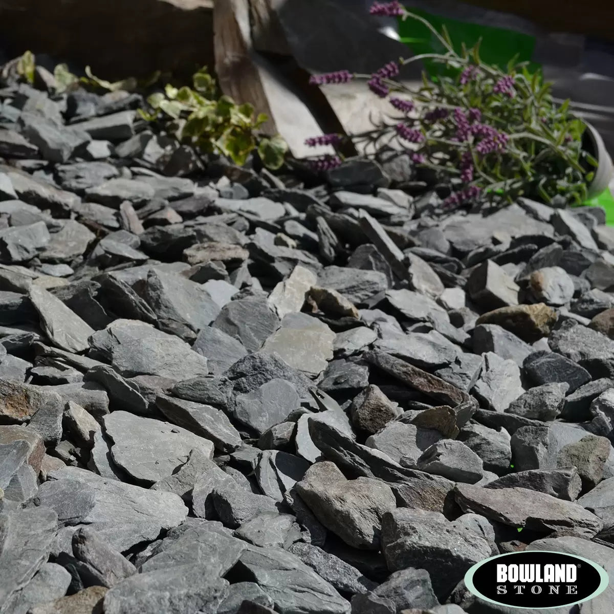 A close-up view of crushed green slate stones showing textured, natural finish and varying shades of green, suitable for garden borders and pond landscaping.