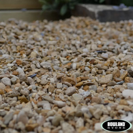 A close-up of 6-10mm multi-colored Bowland Stone Pea Gravel inside a 750kg bulk bag for garden use.