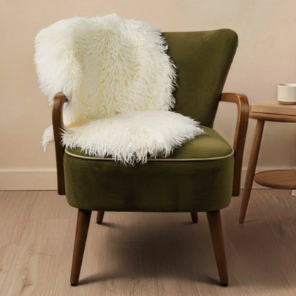 Natural beige Bowron Back Country sheepskin rug with plush curly wool texture draped neatly over a cozy wooden armchair.