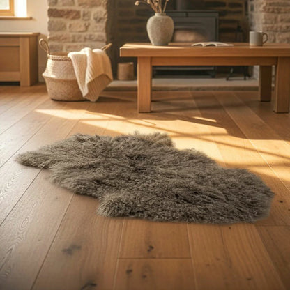 Overhead shot of a soft white Bowron Tibetan Sheepskin Rug draped across a Scandinavian wooden armchair showing long, silky wool curls.