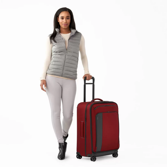 Three-quarter angle view of the black Briggs & Riley ZDX 66cm Medium Expandable Spinner Suitcase highlighting its exterior handle, zip expansion, and smooth dual spinner wheels on a neutral background.