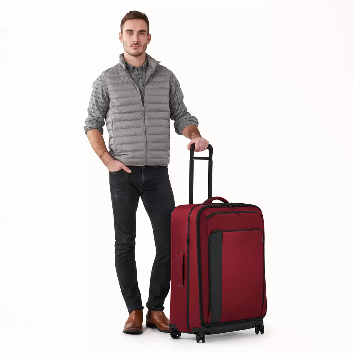 Front angle view of the black Briggs & Riley ZDX 74cm Large Expandable Spinner Suitcase showing exterior front zip pockets, rugged corner guards, and smooth spinner wheels against a crisp white background.