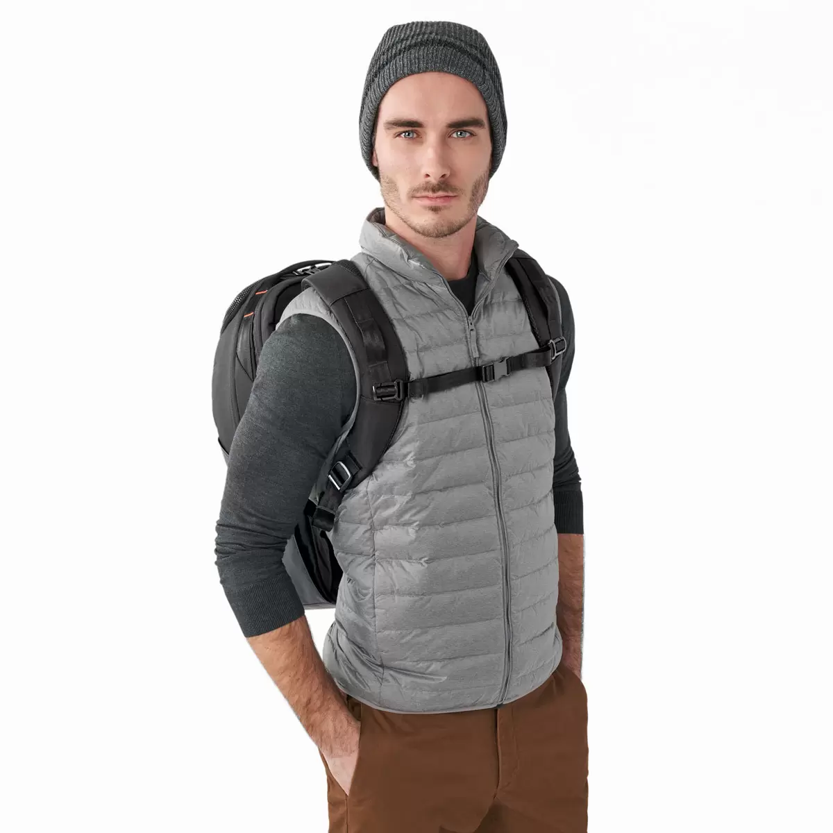 Black Briggs & Riley ZDX Cargo Backpack showcasing top cargo pocket, side zip compartments, and water-resistant PVC base resting on a wooden surface.