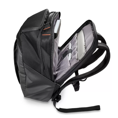 Black Briggs & Riley ZDX Cargo Backpack showcasing top cargo pocket, side zip compartments, and water-resistant PVC base resting on a wooden surface.