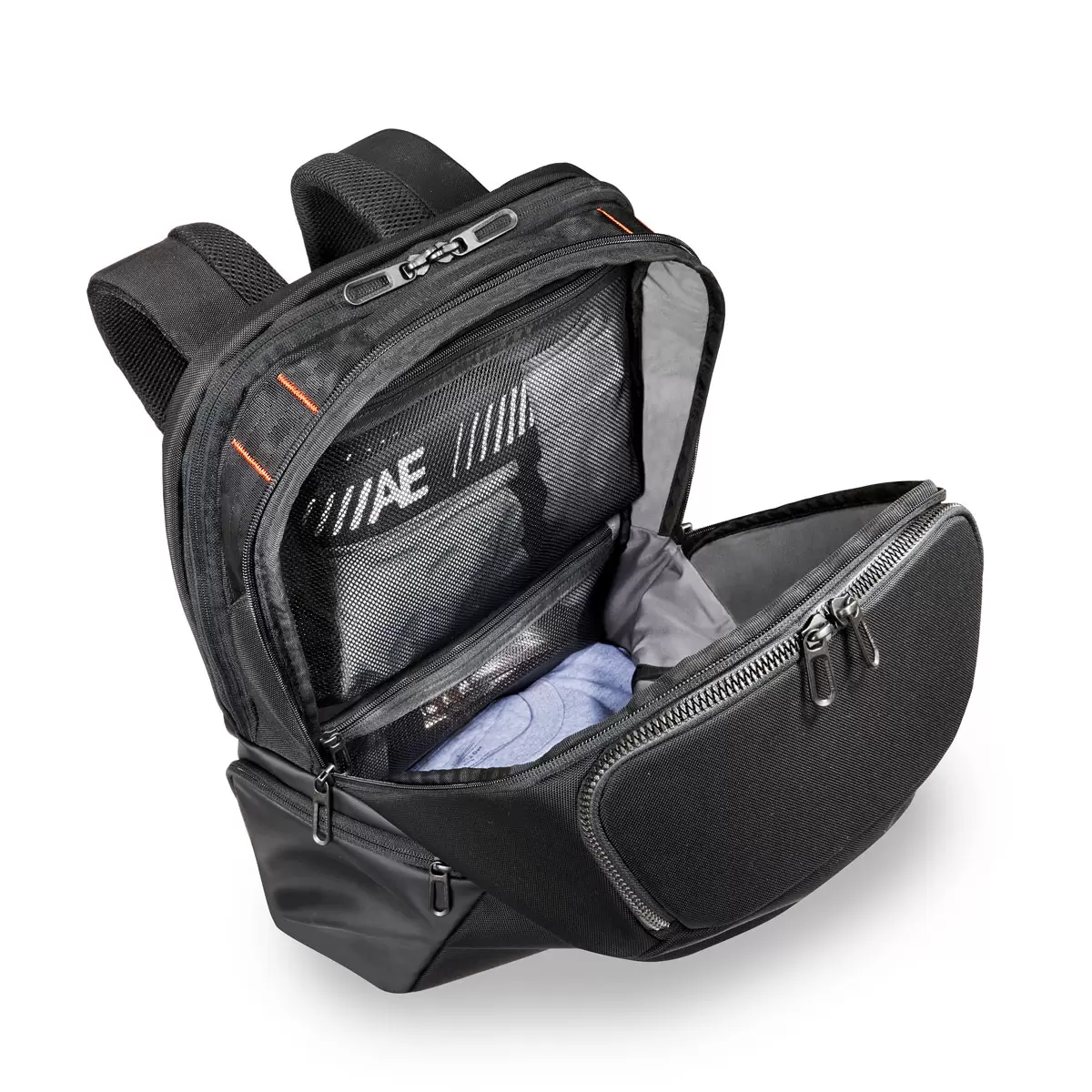 Black Briggs & Riley ZDX Cargo Backpack showcasing top cargo pocket, side zip compartments, and water-resistant PVC base resting on a wooden surface.