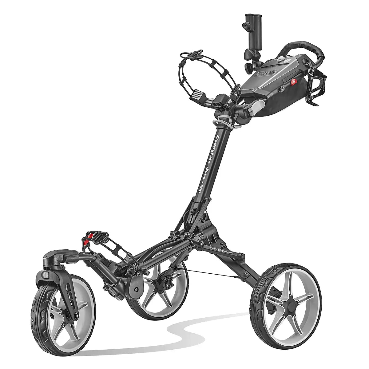 Side view of the grey Caddytek CaddyLite Auto+360 aluminium golf trolley parked on a lush green fairway, showcasing its wide-profile wheels and folded umbrella accessory in the holder.