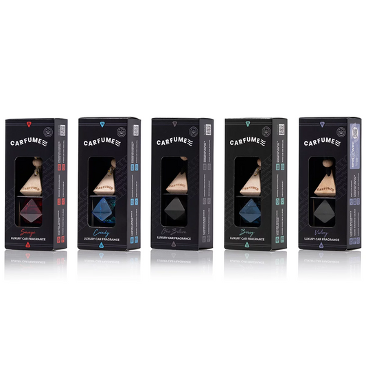 Five small square glass car diffusers with hanging cords and light-colored wooden caps, filled with golden fragrance oils, arranged in a row on a black background.
