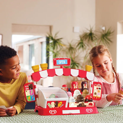 Front view of the colorful plastic Casdon Walls Deluxe Ice Cream Parlour Playset featuring toy ice cream cones, scoops, plastic tubs, and play money set up on a white background.