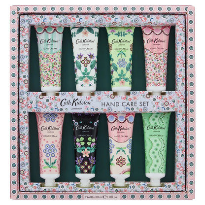 Flat lay arrangement of eight colorful Cath Kidston 30ml hand cream tubes featuring hand-painted flower patterns around an opened gift box.
