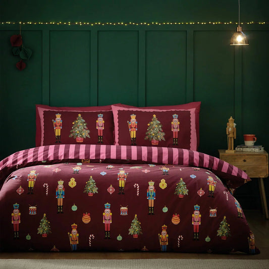 Catherine Lansfield Christmas nutcracker stripe reversible duvet cover set with matching pillowcases arranged neatly on a dressed bed.