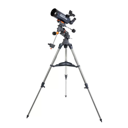 Profile shot of the metallic blue Celestron 90EQ Astromaster Maksutov-Cassegrain telescope mounted on its steel equatorial tripod, positioned against a clean minimalist studio backdrop.