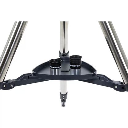 Profile shot of the metallic blue Celestron 90EQ Astromaster Maksutov-Cassegrain telescope mounted on its steel equatorial tripod, positioned against a clean minimalist studio backdrop.
