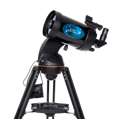 Three-quarter studio angle of the black Celestron Astro Fi 5 inch Schmidt-Cassegrain telescope mounted on its aluminum tripod with a smartphone docked onto the eyepiece adapter.