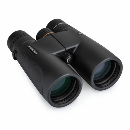 Front angle view of the dark green Celestron Nature DX 10x50mm binocular showing the massive multi-coated objective lenses resting on a mossy rock.