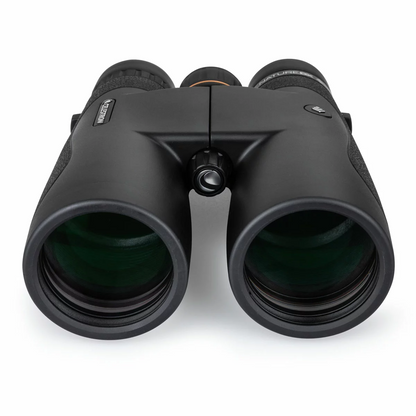 Front angle view of the dark green Celestron Nature DX 10x50mm binocular showing the massive multi-coated objective lenses resting on a mossy rock.