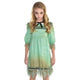 Front view of a young girl wearing a distressed vintage-style creepy doll Halloween dress standing in a dimly lit doorway.