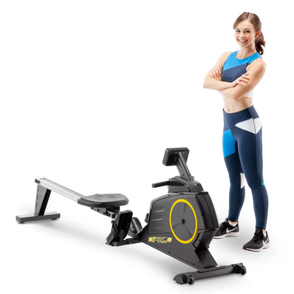 Black Circuit Fitness 986RW Deluxe Magnetic Folding Rowing Machine shown from a side angle with digital LCD console, foam handlebar, and extended steel rail set up in a modern home workout area.