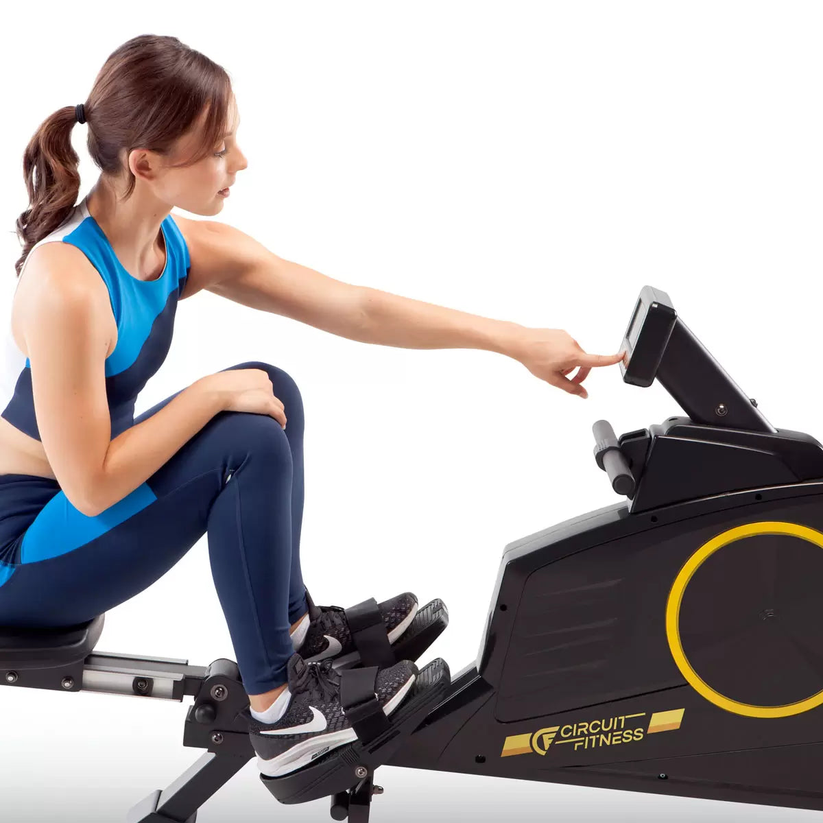 Black Circuit Fitness 986RW Deluxe Magnetic Folding Rowing Machine shown from a side angle with digital LCD console, foam handlebar, and extended steel rail set up in a modern home workout area.