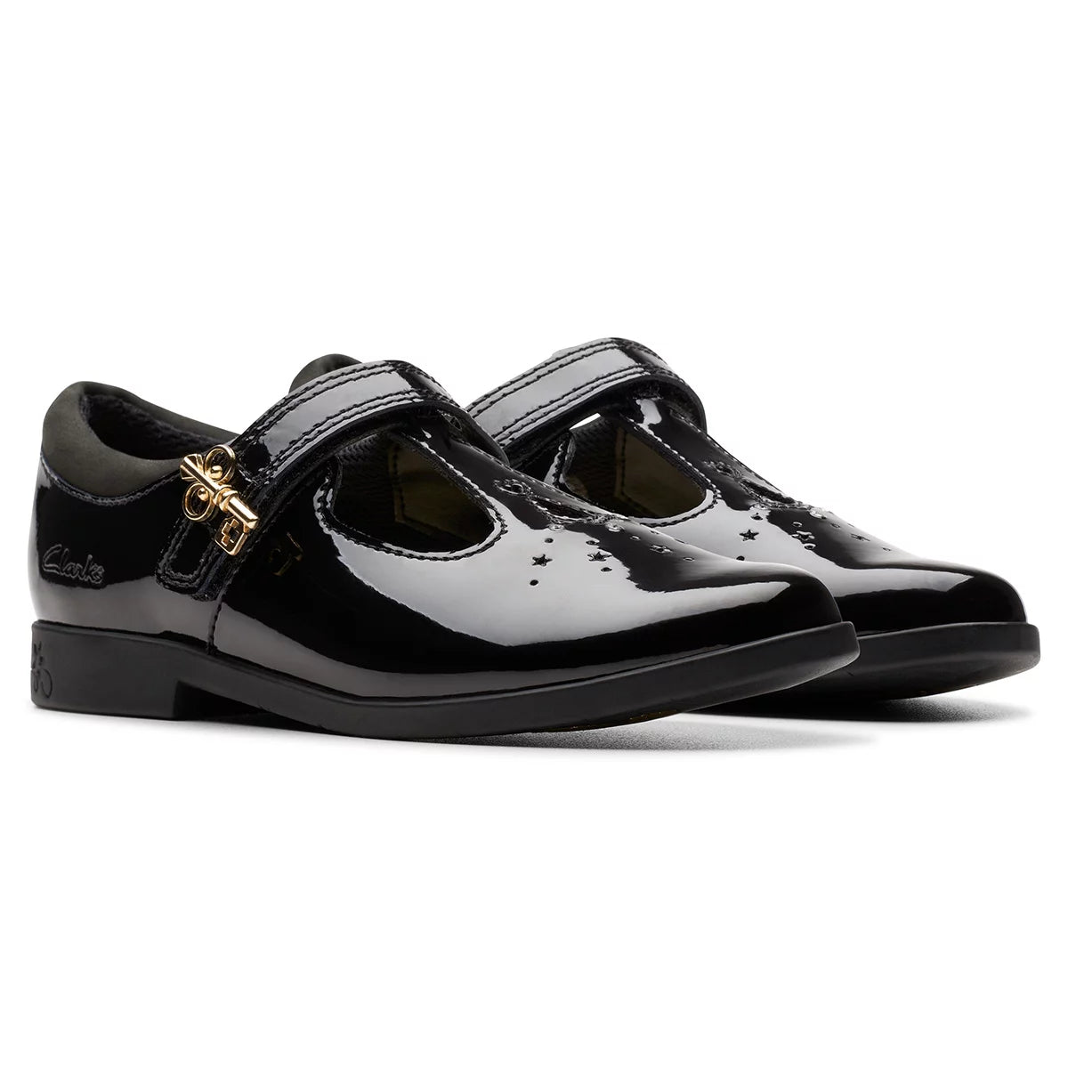 Side angle view of Clarks Kids Lock Shine black patent T-bar school shoes featuring a buckle accent and grippy rubber sole.