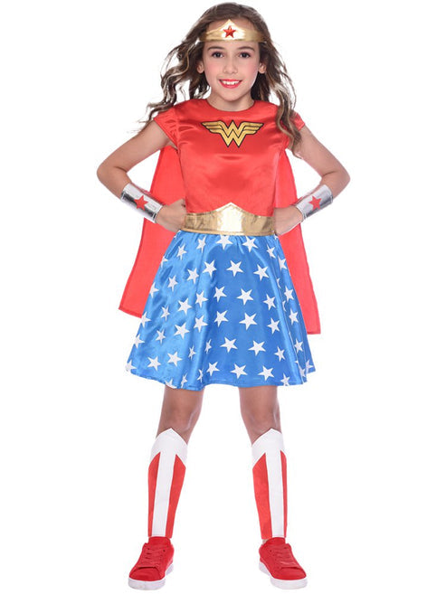 Child wearing the Classic Wonder Woman outfit featuring a red bodice, blue star skirt, gold tiara, and wrist gauntlets in a bright playroom.