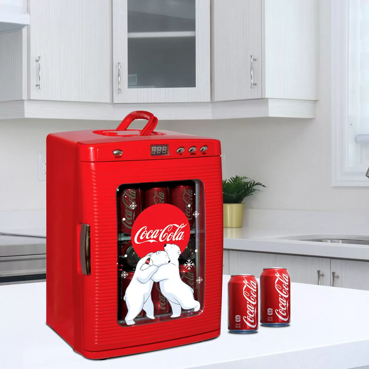 Vibrant red Coca-Cola 25L mini fridge with polar bear graphics and chrome handles, glowing with LED interior light through its tempered glass door on a sleek desk.